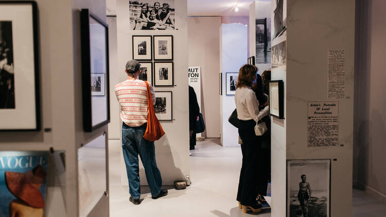 Several people view photographs in a gallery