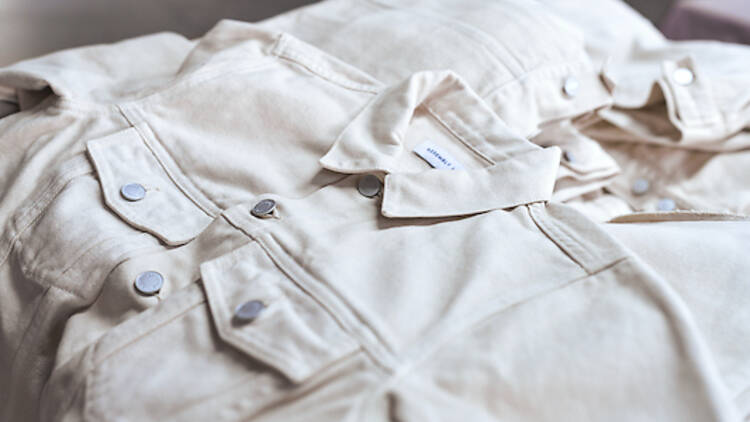 A close-up of a white denim jacket and white denim pants.