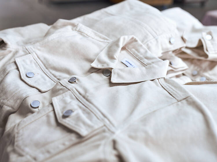 A close-up of a white denim jacket and white denim pants.