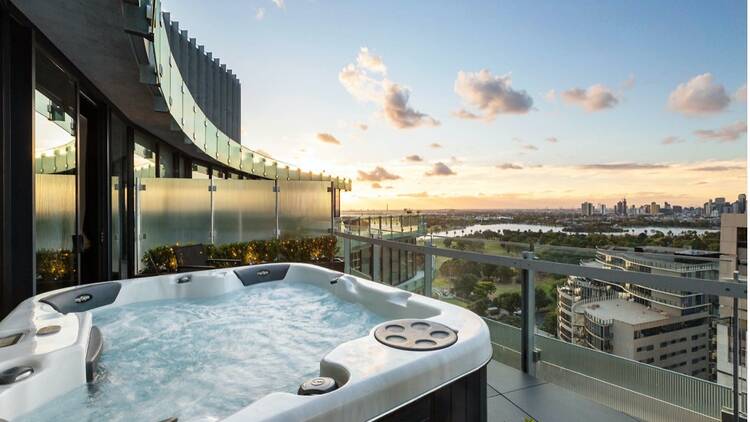 A balcony with a large hot tub with jets running.