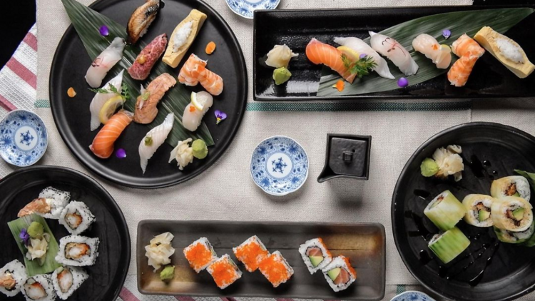 Several platters of sushi on a table.