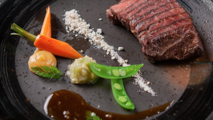 Wagyu steak cut into slices and served with steamed vegetables.
