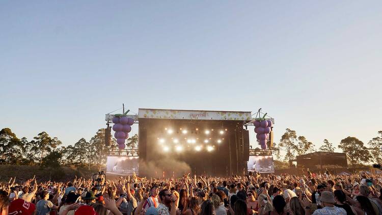 A crowd of people dancing in front of a stage at Grapevine Gathering music festival. 