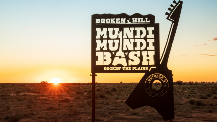 Photograph of the Mundi Mundi Bash sign, a tin silhouette against a desert sunset