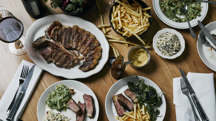 A spread of dishes such as steak and fries