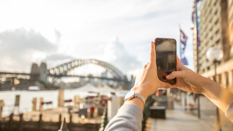 Someone filming the Sydney Harbour Bridge with their phone