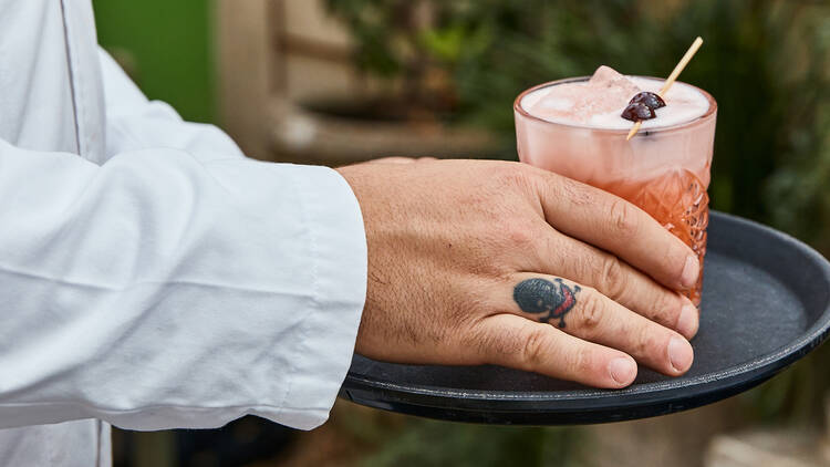 A waiter serving a cocktail