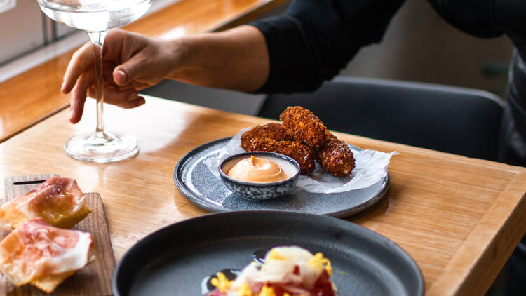 A wooden table topped with three lunch dishes and a Martini at Stillwater Restaurant.