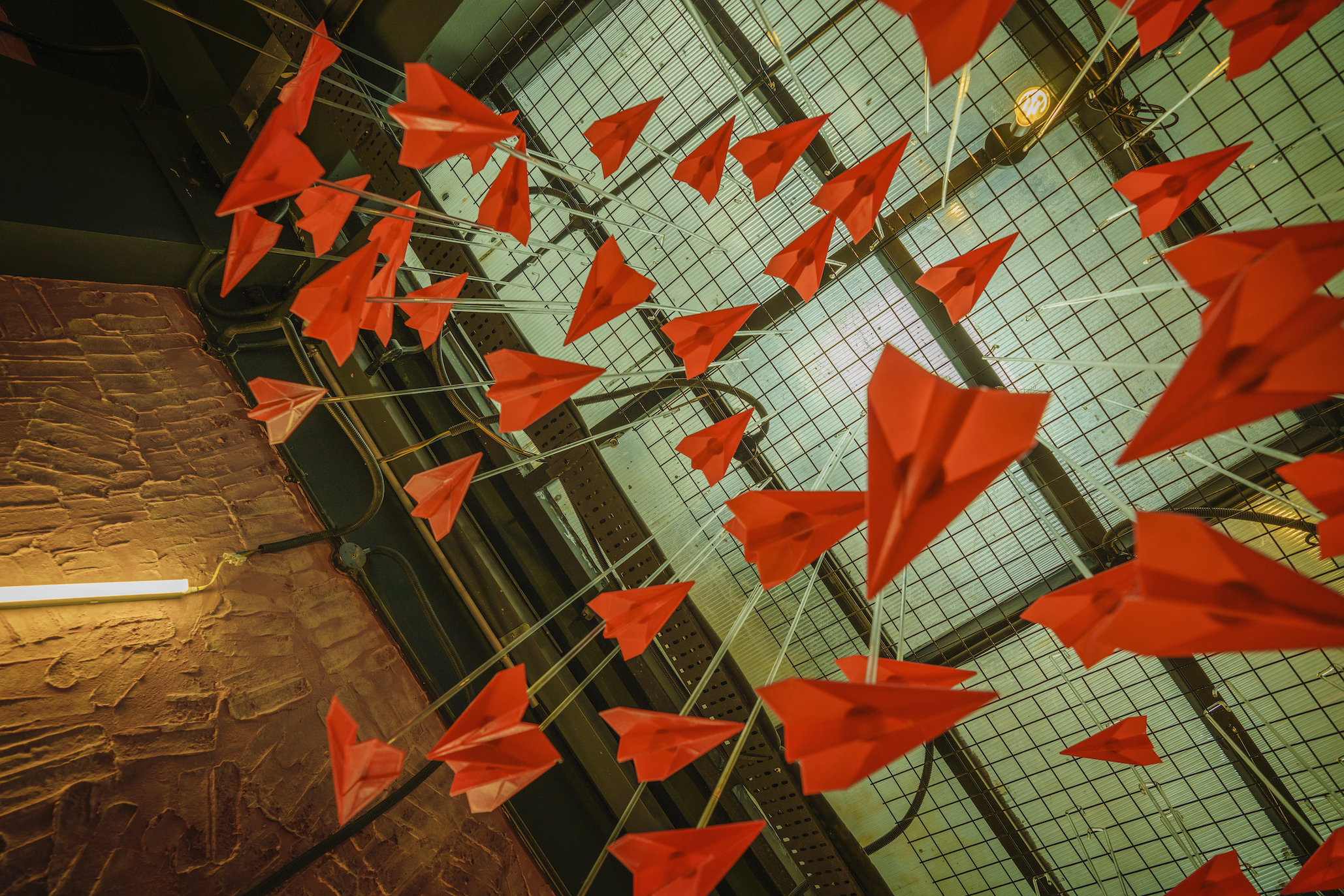 Flocks of red paper planes bejewelling the ceilings