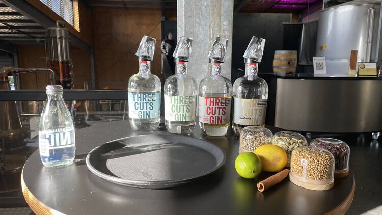 A round table with four bottles of Three Cuts Gin by Turnier Stillhouse. 