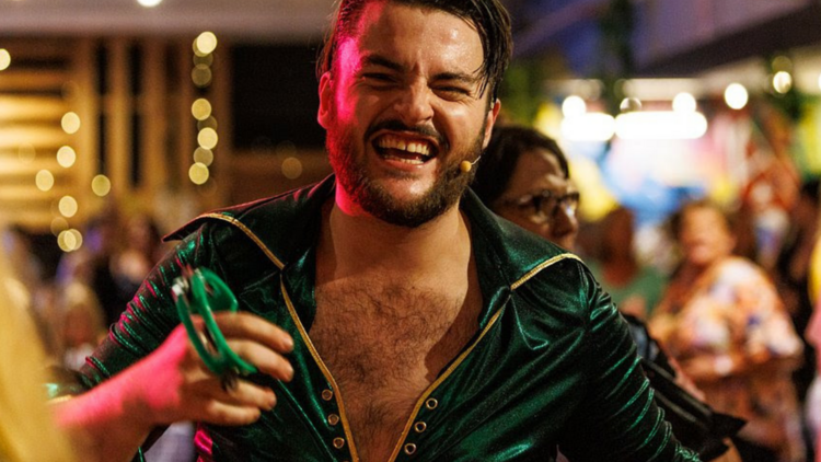 A man in a green jumpsuit smiling