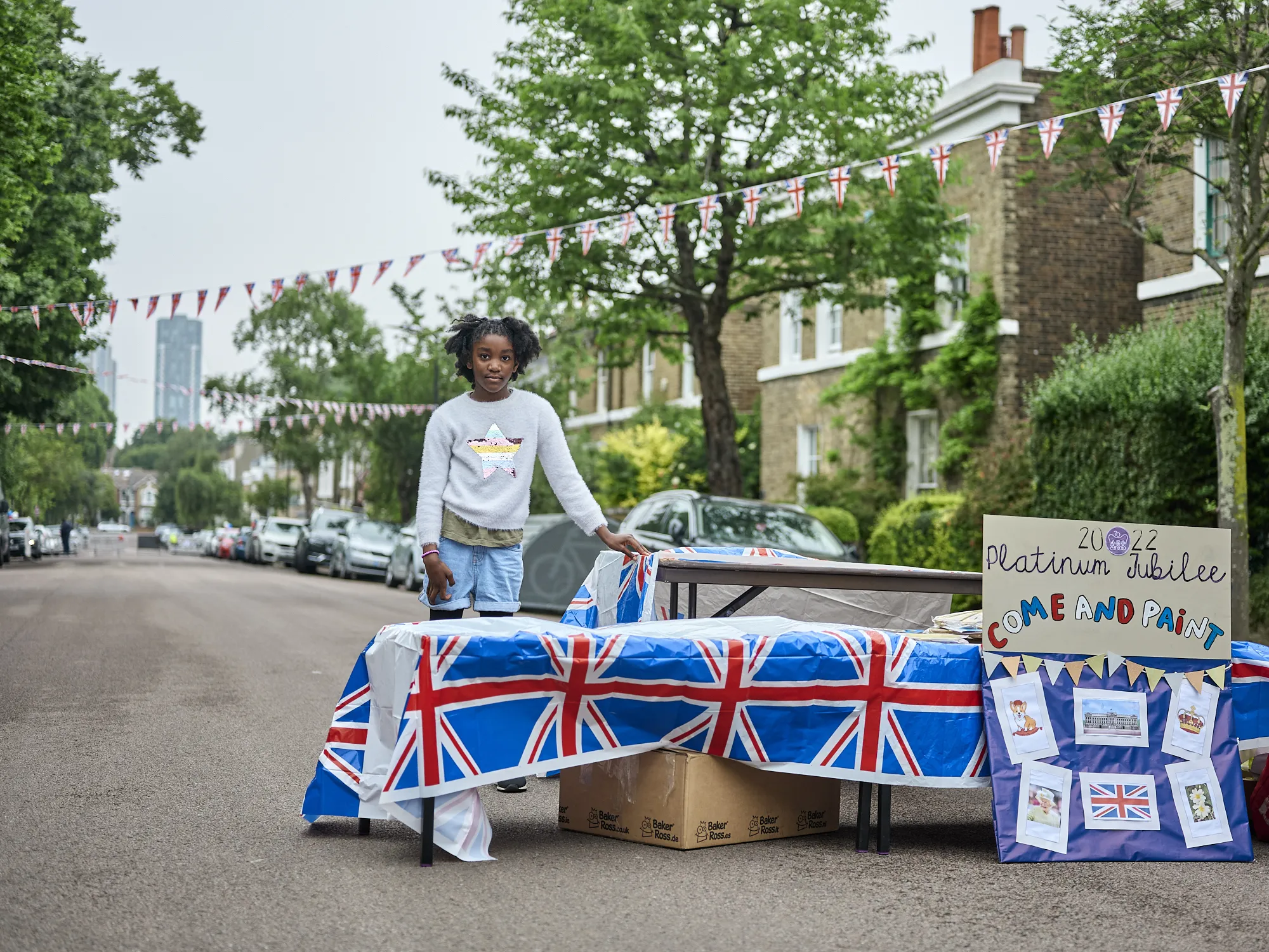 PlatinumJubilee2022_Gili_7827 - A girl setting up a paint stand for a street party in Dynevor Road, Stoke Newington, Sunday 5th June 2022