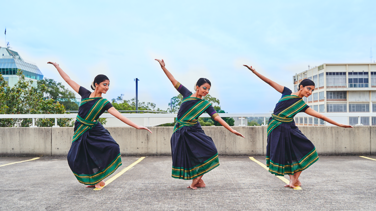 Three women in traditional dress doing the Agal Dance 