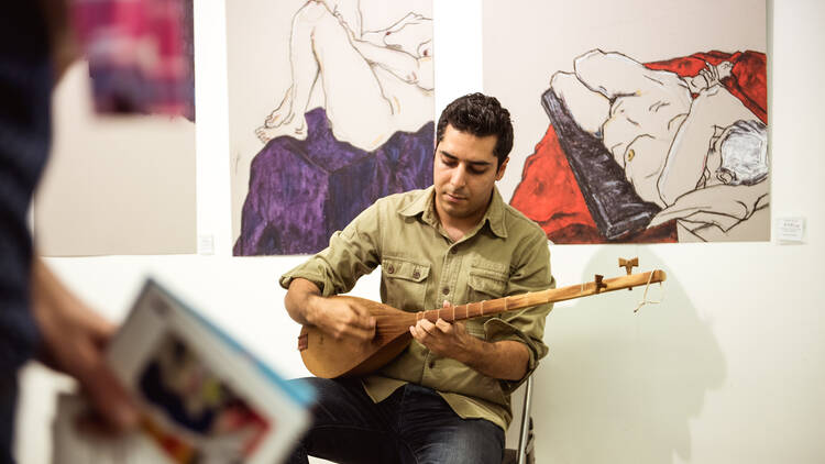 Male artist playing an instrument at an art exhibit