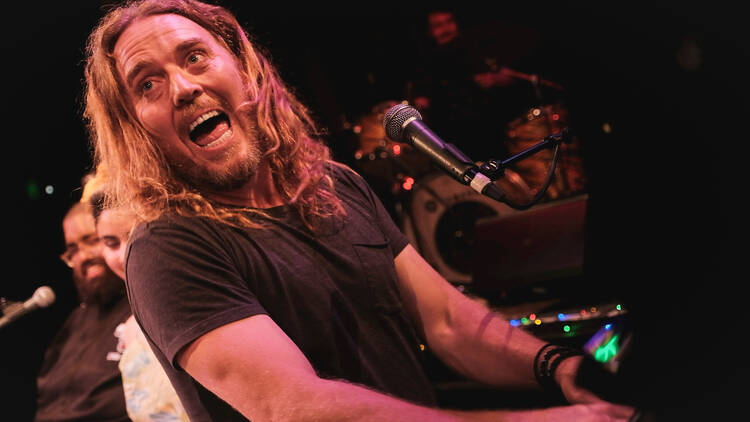 Tim Minchin plays the piano and sings