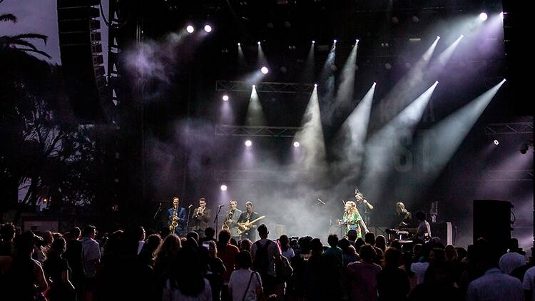 Performers on stage at a beachside concert