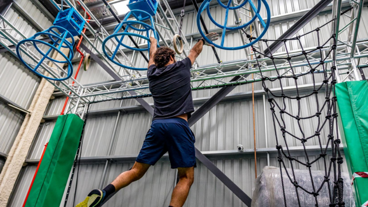 A man swings from the ceiling at Ninja Parc in South Granville