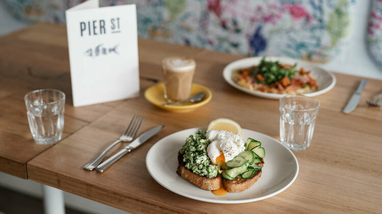 A table with plates of breakfast dishes atop it.