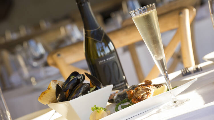 A platter of mussels with a glass of sparkling wine.