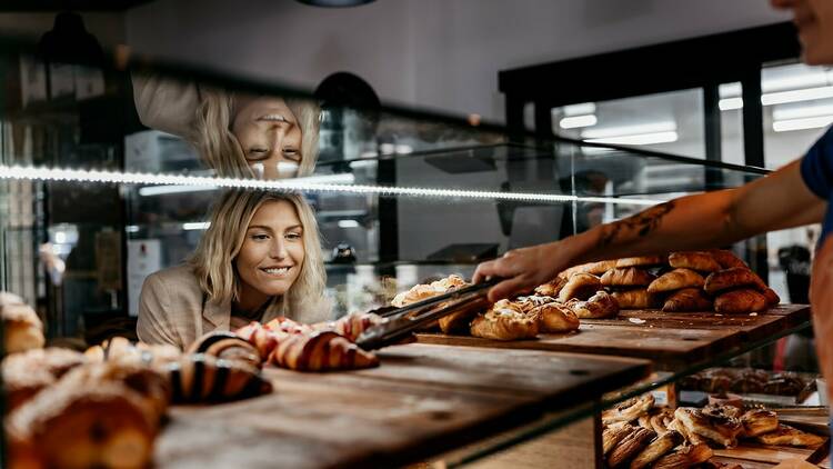 Head baker Miek serving a loaf to a customer.