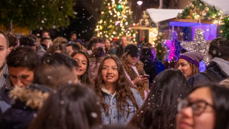 people have snow falling on them at the Christmas in July markets at the Rocks