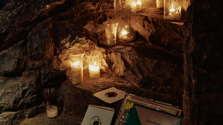 A stoney stairwell with vinyls and candles.