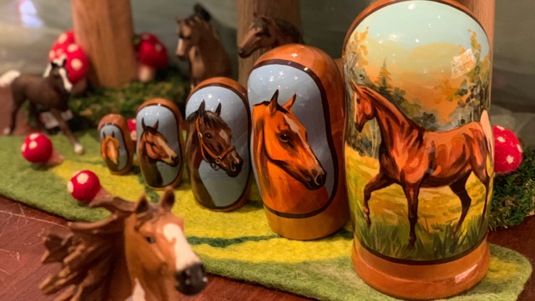A set of nesting toys painted with horses.