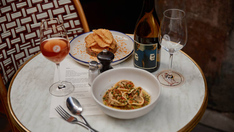 Dumplings and steak tartare served with wine.