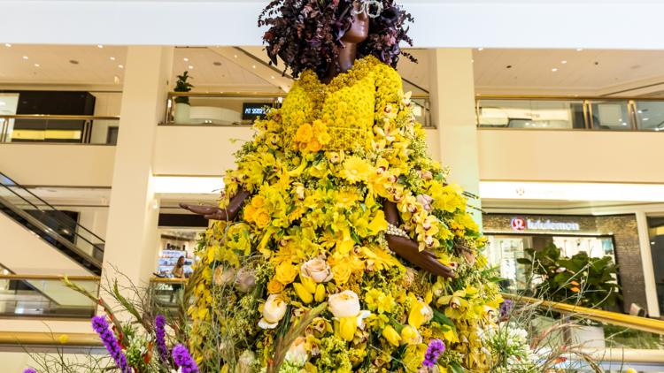 A mannequin shaped like Oprah Winfrey is made entirely out of flowers