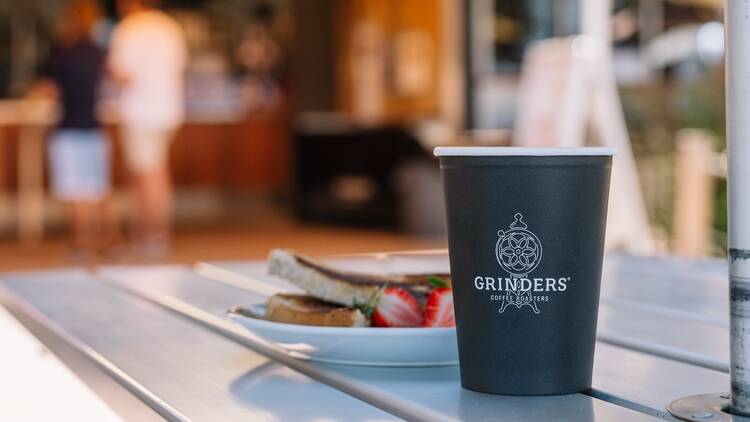 A takeaway coffee cup and a sandwich in a café 