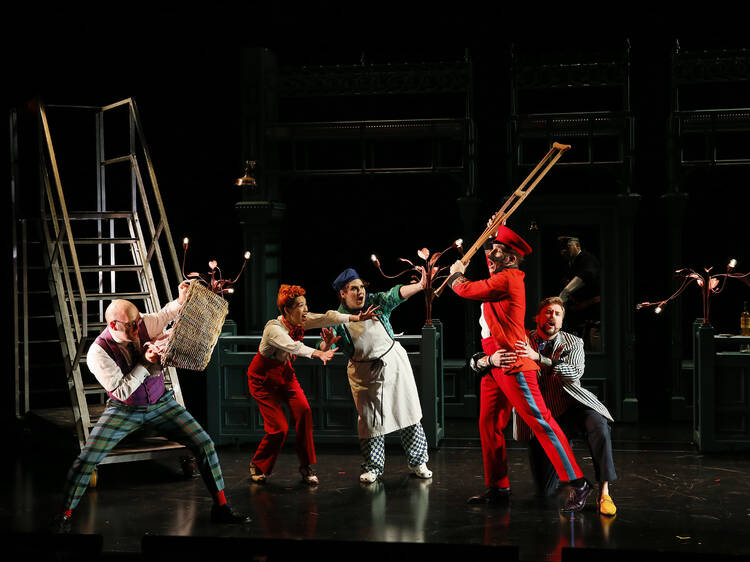 A group of actors performing The Barber of Seville on stage.