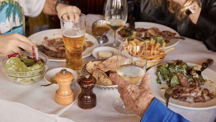 A table with steak frites, salads and more. 