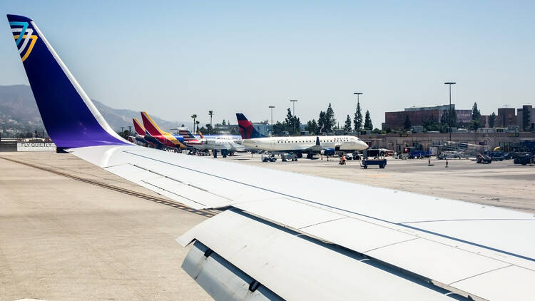 The wing of the Avelo airplane landed in the airport of Burbank Los Angeles airport on a sunny day