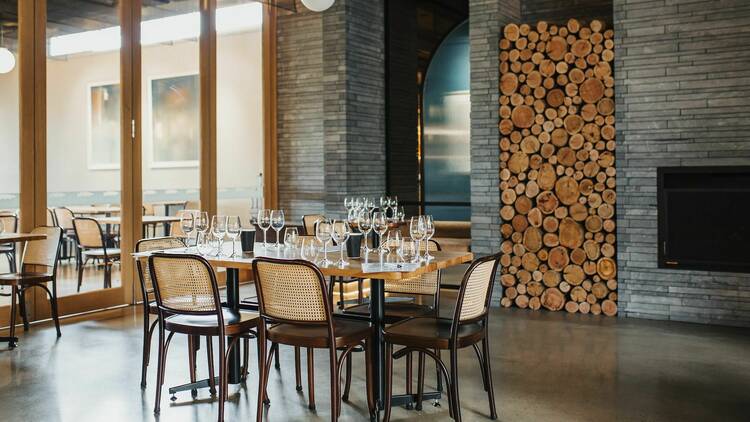 In the Pikes Winery dining room, a table is set with clean tasting glasses beside the fireplace
