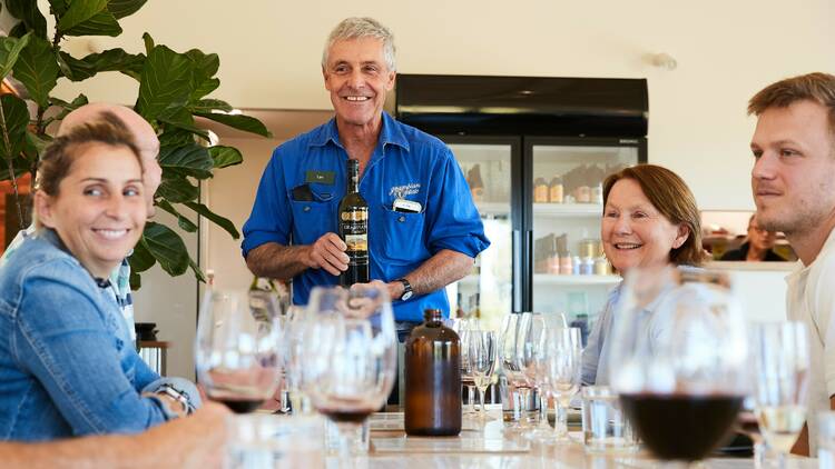 Grampians Estate owner Tom leading a wine tasting around a table.