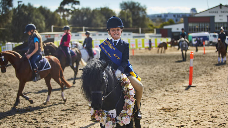 A child riding a horse at the Royal Melbourne Show.