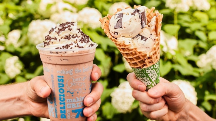 A chocolate milkshake and an ice cream cone in front of flowers