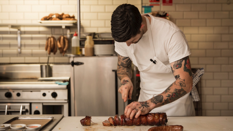 Luke Powell slicing lamb belly