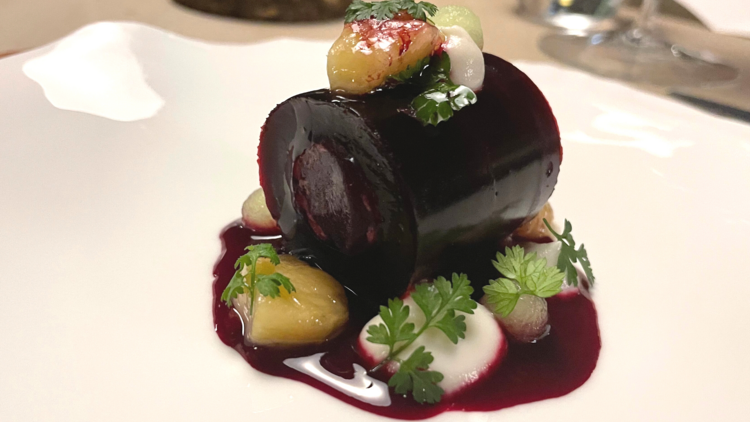 A cylinder of beetroot in a plum-red sauce with bits of bone marrow.