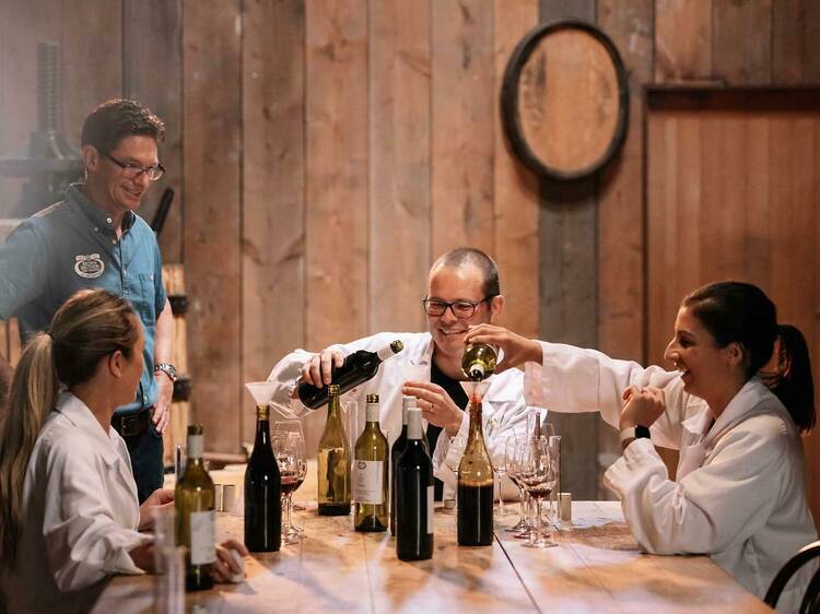 A group of people blending their own bottles of wine.