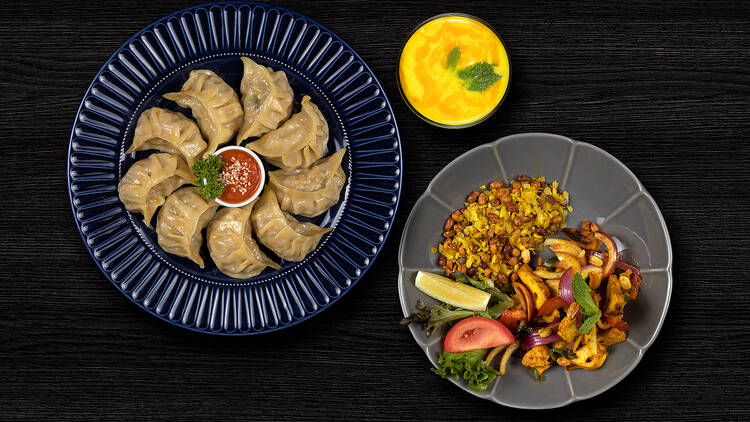 Nepali specials, including a plate of momo dumplings paired with chilli sauce.