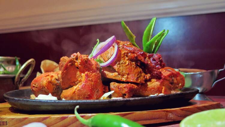 Tandoori garnished with onion served at Taj Mahal.