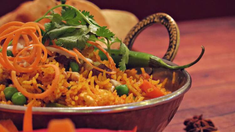 A dish of Biriyani garnished with carrot, chilli peppers and coriander, served at Taj Mahal. 