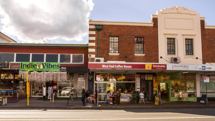 A photograph of the outside of Govindas West End and the shops next to it on the strip it is located.