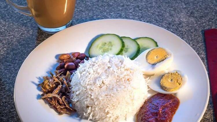 A plate of Malaysian food at Mamak Tandoori House, containing rice, cucumber, and egg.