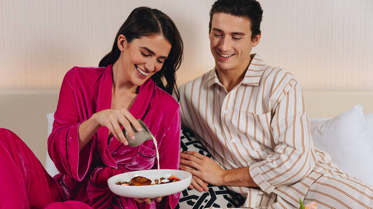 A couple enjoying room service in a hotel room.