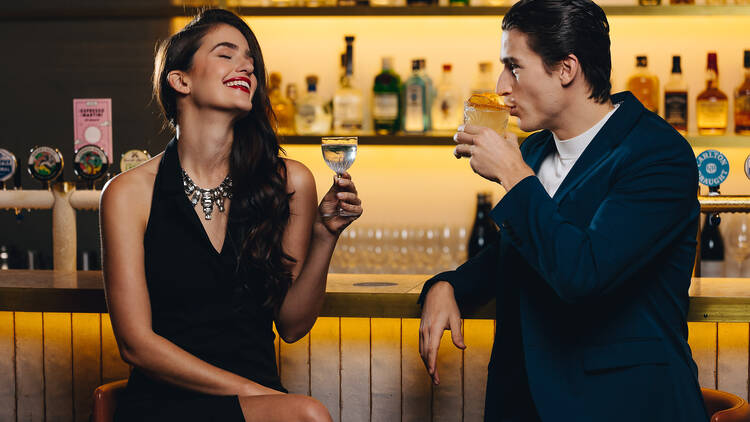 A couple enjoying cocktails at a hotel bar.