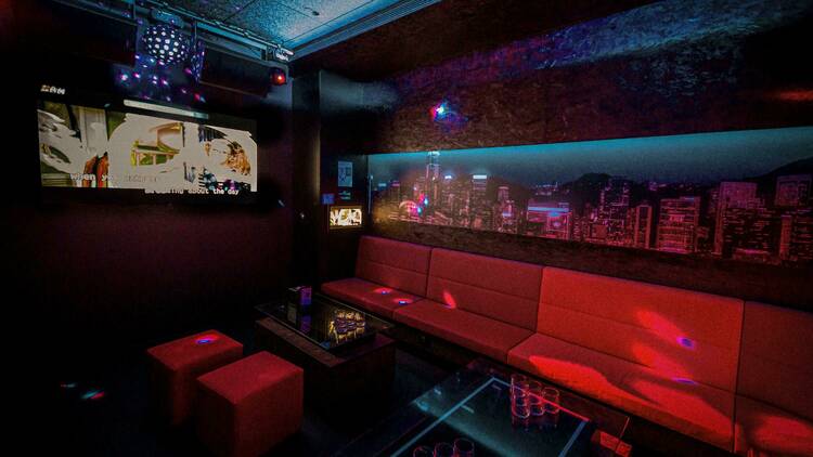 A karaoke room with a Hong Kong cityscape on the wall