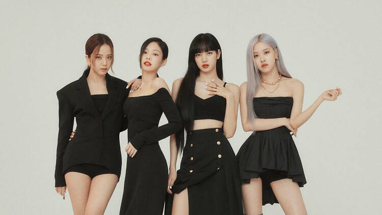 The members of kpop band Blackpink stand on a white background in various black outfits