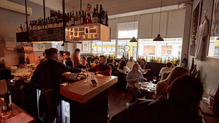 A shot of the interior bar and dining room of Bar Liberty, filled with people.